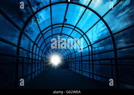 Tunnel sinistre bleu foncé avec des ombres sur les murs et la lumière à la fin de c Banque D'Images