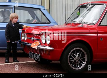 Zach Stuart, un passionné de voitures de quatre ans, polit un Imp Hillman alors que les voitures se préparent à quitter en convoi le site de l'ancienne usine de Linwood pour marquer le 50e anniversaire de la première Imp Hillman fabriquée à l'usine de Rootes. Banque D'Images
