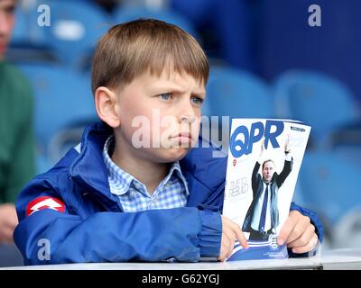 Un jeune fan des Queens Park Rangers organise un programme d'allumettes Banque D'Images