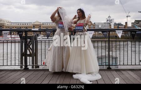 Toby et Sophie McCorry participent à un appel photo près de Tower Bridge à Londres, avant de participer au marathon de Londres de dimanche, où ils tenteront de devenir les coureurs les plus rapides portant des robes de mariée et espèrent participer au Livre Guinness des records. Banque D'Images