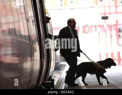 Roger Bailey et son chien-guide Jess débarquent d'un train à la gare Marylebone de Londres, lors d'une séance photo pour lancer la campagne « accès pour tous » de l'Association des chiens-guides pour les aveugles, qui vise à faciliter l'utilisation des transports en commun par les personnes handicapées. Banque D'Images