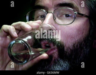 Le président de Sinn Fein, Gerry Adams, prend un verre d'eau dans son bureau sur la route des chutes à Belfast. Demain, il rencontrera le Premier ministre britannique Tony Blair à Downing Street à Londres pour entendre le sort de son parti. * M. Adams a déclaré qu'il n'y avait aucun motif d'expulser son parti de l'exécutif de partage du pouvoir en Irlande du Nord et a ajouté que le gouvernement irlandais doit continuer son opposition à toute suspension des institutions. Banque D'Images