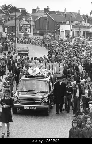 Les bourneurs en deuil marchent derrière les corbillards portant les cercueils des trois jeunes enfants Maguire, tués par une voiture garée, pendant la procession funéraire de l'église catholique romaine de Finnaghy Road Nord au cimetière de Milltown à Belfast. Les magasins, les bars et les usines ont fermé tandis que les travailleurs ont assisté à la grande procession de 1,000, dont la foule était estimée à 5,000 personnes. Banque D'Images