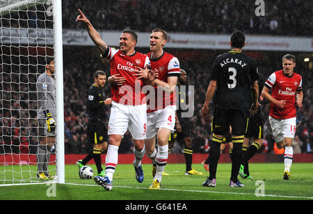 Football - Barclays Premier League - Arsenal / Wigan Athletic - Emirates Stadium.Lukas Podolski d'Arsenal (à gauche) célèbre avec Per Mertesacker (à droite) après avoir marquant le but d'ouverture du match contre Wigan Athletic. Banque D'Images