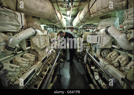 Un ingénieur mécanique de la Royal Navy vérifie l'un des deux moteurs diesel V16 qui fournissent de l'électricité au HMS Edinburgh lors de la visite d'adieu du navire au Royaume-Uni en direction de Leith, Édimbourg, où le dernier destructeur de type 42 de la Royal Navy effectuera sa dernière visite à Édimbourg avant sa mise en service. Banque D'Images