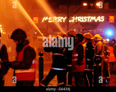 Les pompiers de l'armée et du service s'attaquent à un incendie majeur dans le centre de Stockton on Tees décorations de Noël restent illuminés dans la rue principale de la ville. Banque D'Images