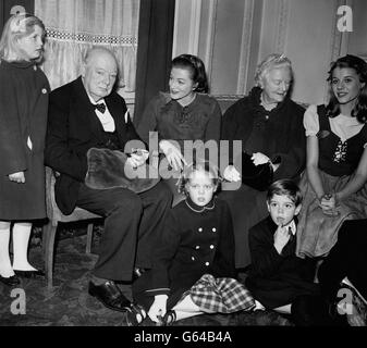 Sir Winston Churchill, Lady Churchill et une fête de famille après avoir assisté à une représentation de Peter Pan dans laquelle la fille de l'actrice de Churchill, Sarah, au centre, toujours en costume, joue Peter.Autour de Sir Winston et de Lady Churchill se trouvent trois de leurs petits-enfants, Arabella (à gauche), et Emma et Jeremy Soames.À droite de Lady Churchill se trouve Julia Lockwood, qui joue Wendy. Banque D'Images