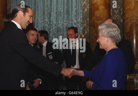 La reine Elizabeth II rencontre le gardien de but de l'Angleterre David Seaman, lors d'une réception pour l'Association de football qui s'est tenue au Palais de Buckingham.* le parti d'Angleterre de 75-forte, y compris le personnel de l'arrière-salle ainsi que les joueurs de haut profil et la direction, sont arrivés au Palais en trois entraîneurs.La réception de boissons et de canapés a été organisée dans la salle de dessin bleue du Palais où le président de la FA, Geoffrey Thompson, ainsi que l'entraîneur et le capitaine de l'Angleterre, ont été les premiers à rencontrer la Reine.Bien qu'il ne s'agisse pas d'un fan de football naturel, la Reine a été connue pour devenir très animée lorsqu'elle suit l'équipe d'Angleterre à la télévision. Banque D'Images