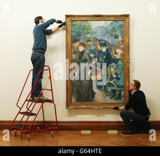 (De gauche à droite) Simon Lawlor et Ger Crotty pendent les Parapluies de Renoir (les parapluies), quatre tableaux impressionnistes étant retournés à la Hugh Lane Gallery, Dublin, de la National Gallery de Londres. Banque D'Images