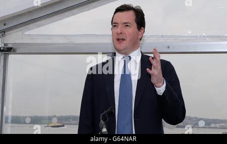 Le chancelier de l’Échiquier George Osborne s’entretient avec les travailleurs du port de Liverpool au cours d’une visite pour marquer le début du dragage de l’estuaire de la rivière Mersey. Banque D'Images