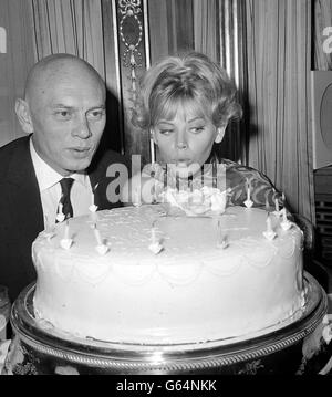 L'acteur YUL Brynner et l'actrice née en Suède Britt Ekland (Mme Peter Sellers) s'unissent pour souffler les bougies sur un gâteau d'anniversaire lors d'une réception à l'hôtel Dorchester, Park Lane, Londres. Banque D'Images