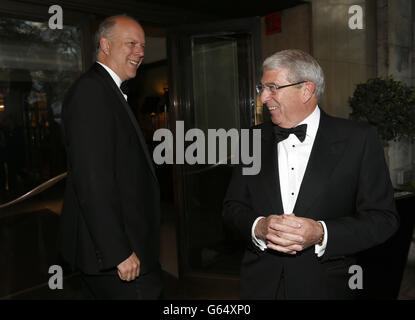 Le secrétaire d'État à la Justice Chris Grayling (à gauche) est accueilli par le président de la CBI Sir Roger Carr (à droite) lorsqu'il arrive au dîner annuel de la CBI qui s'est tenu à l'hôtel Grosvenor House, à Londres. Banque D'Images