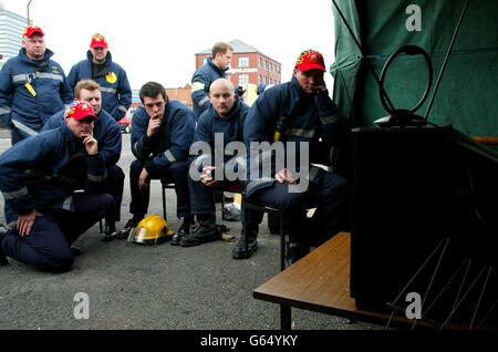 Les pompiers sur une ligne de piquetage à la caserne de pompiers de Thompson Street à Manchester regardent le Premier ministre britannique Tony Blair tenir sa conférence de presse télévisée mensuelle à Downing Street. Banque D'Images