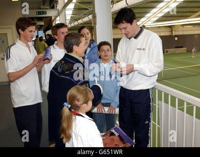 La star britannique du tennis Tim Henman signe des autographes alors qu'il regarde le jeu lors des finales nationales des compétitions 2002 de l'équipe de tennis des écoles britanniques/HSBC au centre sportif Redbridge à Barkingside, Essex. Banque D'Images