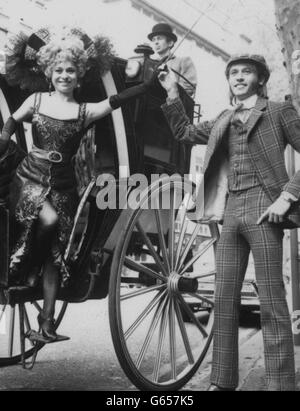 La Reine du Music Hall, Marie Lloyd, en forme d'actrice Barbara Windsor, a traversé le West End de Londres.Barbara décrit « notre Marie », dans la nouvelle comédie musicale Ned Sherrin/Caryl Brahma, « Sing a rude Song », basée sur la vie de Marie, et ici elle est aidée d'un taxi hanson 1880 par sa co-star, Maurice Gibb,Le couple venait d'arriver au Garrick Theatre, où le spectacle, transféré du Greenwich Theatre, ouvrait mardi.Marie Lloyd avait l'habitude de se précipiter entre les engagements dans les salles de musique au moyen d'un taxi hansom. Banque D'Images