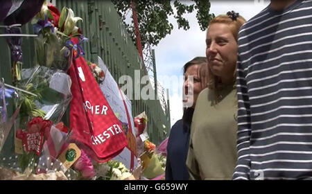 Videograb image prise de PA Video de Aimee West (kaki to), le fiancé du batteur soldat assassiné Lee Rigby regardant les hommages floraux laissés près de la scène de sa mort à Woolwich, dans le sud-est de Londres hier. Banque D'Images