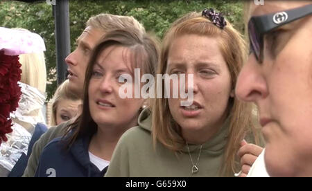 Videograb image prise de PA Video de Aimee West (kaki to), le fiancé du batteur soldat assassiné Lee Rigby regardant les hommages floraux laissés près de la scène de sa mort à Woolwich, dans le sud-est de Londres hier. Banque D'Images