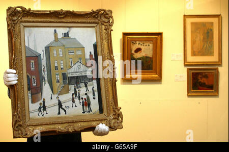 Un porteur à la maison de vente aux enchères de Sotheby à Londres tient 'The White Shop'.La peinture de Laurence Stephen Lowry sera vendue à Sotheby's le 16 décembre 2002 avec un prix guide de 200,000-300,000 livres dans le cadre de la collection Charles et Barbara Robertson. Banque D'Images