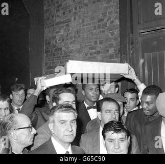 Américain lourd Cassius Clay, Qui a tenu sa promesse la nuit dernière en battant le champion britannique de poids lourd Henry Cooper au cinquième tour de leur combat à Wembley, tient huit doigts pour indiquer qu'il va prendre huit tours pour battre son prochain adversaire, Sonny Liston, après avoir quitté son hôtel à Piccadilly à Londres. Banque D'Images