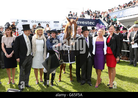 Le dirigeant du monde copropriétaires Michael Tabor (deuxième à gauche) et Derrick Smith (troisième à droite) avec le jockey Ryan Moore (quatrième à gauche) après la victoire dans le Derby Investec Banque D'Images