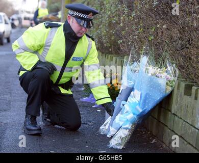 Un policier dépose un bouquet de fleurs en même temps que d'autres hommages floraux au DC Stephen Oake, devant les appartements de Manchester où il a été poignardé à mort lors d'un raid contre le terrorisme. * M. Oake, père de trois enfants de Poynton à Cheshire, qui a servi au sein de la branche spéciale des forces, est décédé à l'hôpital général de North Manchester après avoir reçu des soins d'urgence sur les lieux. Banque D'Images