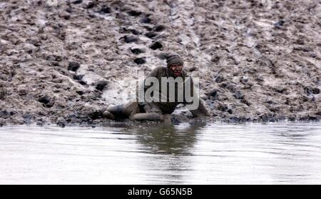 Un concurrent participe à la course annuelle de Maldon Mud à Maldon, dans l'Essex. Des dizaines de concurrents ont glissé et glissé à travers la boue noire mince et l'eau froide de glace dans la course annuelle d'une banque d'une rivière à l'autre. *... la course, qui a commencé en 1973, est située sur la rivière Blackwater dans la ville historique. Les concurrents se sont mis à marée basse d'une banque et se sont mis à nager ou à travers la taille haute de l'eau de l'autre côté. Banque D'Images