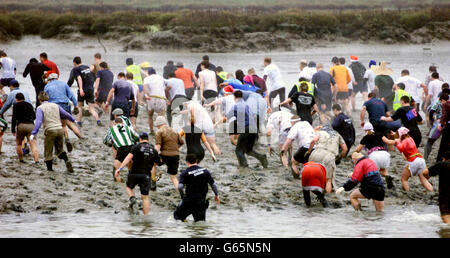 Les concurrents participent à la course annuelle de Maldon Mud à Maldon, dans l'Essex. Des dizaines de concurrents ont glissé et glissé à travers la boue noire mince et l'eau froide de glace dans la course annuelle d'une banque d'une rivière à l'autre. La course, qui a débuté en 1973, se trouve sur la rivière Blackwater, dans la ville historique. Les concurrents se sont mis à marée basse d'une banque et se sont mis à nager ou à travers la taille haute de l'eau de l'autre côté. Banque D'Images