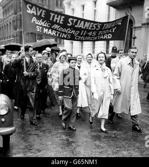 L'acteur Sir Laurence Olivier et son épouse actrice Vivien Leigh sortent devant une bannière. Ils sont vus à la place Saint-James, à Londres, alors qu'ils dirigeaient une procession à travers la pluie du théâtre Saint-James jusqu'à la cour de l'église Saint-Martin-dans-les-champs, Trafalgar Square, où il y avait des discours. La marche publique et la réunion avaient été convoques par l'Equity des acteurs britanniques pour protester contre la fermeture du Théâtre St James et pour attirer l'attention sur la fermeture continue des théâtres dans toute la Grande-Bretagne. Banque D'Images