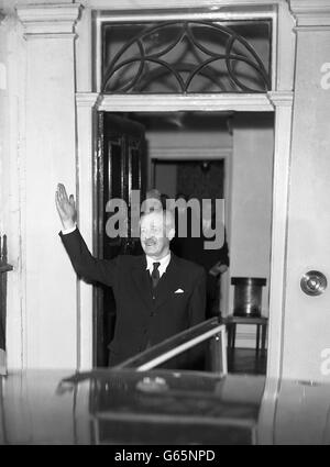 En souriant, bonne humeur, le nouveau Premier ministre britannique Harold MacMillan. Il se fait la vague vers la foule qui applaudit dans Downing Street alors qu'il quitte le no 11 pour dîner dans un club. Banque D'Images