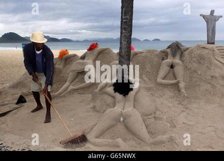 Un sculpteur de sable travaille sur sa sculpture de dames de soleil sur le Copacabana à Rio de Janeiro. Banque D'Images