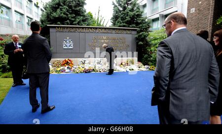 Les gens attendent de regarder les couronnes laissées en hommage à plus de 650 officiers qui sont morts en service depuis la formation du MPS en 1829, à la suite de la cérémonie du souvenir du Metropolitan police Service (MPS), dans le jardin commémoratif du quartier général de formation du Metropolitan police Peel Centre à Hendon, Colindale, Londres.APPUYEZ SUR ASSOCIATION photo.Date de la photo: Vendredi 28 juin 2013.Le crédit photo devrait se lire comme suit : Nick Ansell/PA Wire Banque D'Images