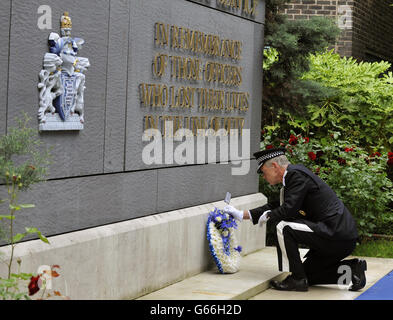 Le commissaire de police métropolitaine, Sir Bernard Hogan-Howe, dépose une couronne au cours d'une cérémonie en hommage à plus de 650 officiers qui sont morts en service depuis la formation du MPS en 1829, lors de la cérémonie du souvenir du Metropolitan police Service (MPS),Dans le jardin commémoratif du centre de formation de la police Métropolitaine Peel à Hendon, Colindale, Londres. Banque D'Images