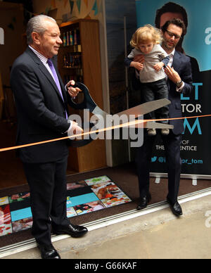 Lord Sugar coupe le ruban dans un magasin de Convent Garden, Londres, en tant que l'inventeur Tom Pellereau, qui a remporté la série 2012 de l'apprenti, tient Ren Butler coupe deux de Blackheath, lors du dévoilement de leur dernier produit, un cloueur pour les enfants. Banque D'Images