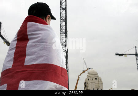 Un jeune fan drapé dans le drapeau de St. George regarde pendant que la démolition commence sur les tours jumelles du stade Wembley à Londres.Une pelle allemande connue sous le nom de « Goliath » a commencé son assaut sur le dôme de la tour ouest juste après 14 h.* les deux tours devraient être abaissent d'ici la fin de lundi, car la mise à niveau du sol entre dans ses étapes finales.Il sera remplacé par un projet de 757 millions de reconversion de l'ensemble du site. Banque D'Images