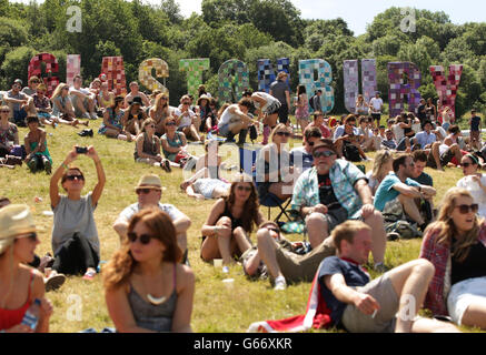 Festivaliers profitant du temps chaud au festival de Glastonbury, à la ferme digne de Somerset. Banque D'Images