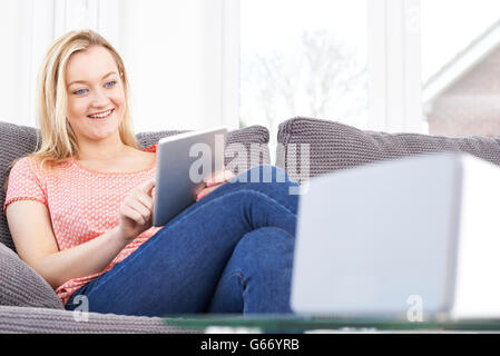 Femme musique en continu à partir du haut-parleur sans fil pour tablette numérique Banque D'Images