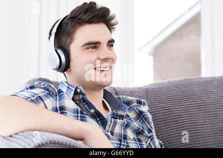 Jeune homme écoute de la musique sur un casque sans fil Banque D'Images