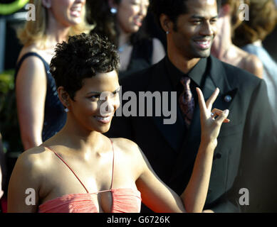 L'actrice Halle Berry affiche un signe de paix lorsqu'elle arrive sur le tapis rouge pour le 9e prix annuel de la Guilde des acteurs de l'écran au Shrine Auditorium de Los Angeles. 21/04/2003: Le gagnant Oscar Halle Berry devrait assister à une première britannique du X-Men 2 plus tard ce mois-ci, il a été confirmé, lundi 21 avril 2003. La sirène d'écran a été invitée à l'événement de collecte de fonds à Édimbourg, qui vise à recueillir des fonds pour la recherche sur le diabète. Berry, qui elle-même est diabétique, est invitée par Brian Cox, un autre patient qui se présente aux côtés d'elle dans le film de science-fiction. Banque D'Images