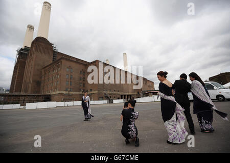 Les membres de la fête d'accueil du premier ministre malaisien se photographient face à la station électrique de Battersea à Londres.Cameron a déclaré qu'il était « à propos du temps » lorsqu'il a salué le début d'un réaménagement de la centrale électrique de Battersea de 8 milliards d'euros. Banque D'Images