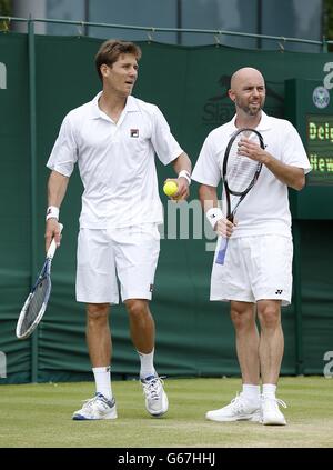 Les grands Britanniques Jamie Delgado (à droite) et l'Australias Matthew Ebden (à gauche) discutent de tactiques contre le Lleyton Hewitt australien et le Mark Knowles de Bahama au cours du quatrième jour des championnats de Wimbledon au All England Lawn tennis and Croquet Club, Wimbledon. Banque D'Images