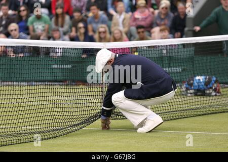 Un juge-arbitre tend vers le terrain pendant le quatrième jour des championnats de Wimbledon au All England Lawn tennis and Croquet Club, Wimbledon. Banque D'Images