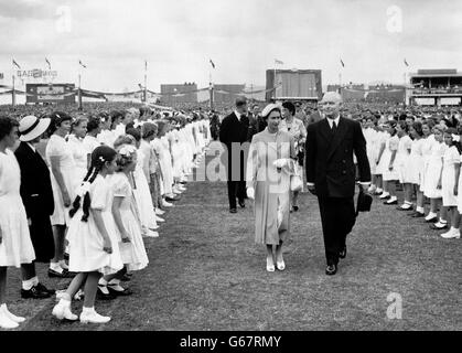 Les enfants blancs se curtsey à la Reine alors qu'elle marche à travers la garde d'honneur montée pour sa visite au gigantesque rassemblement de jeunes à Wayside Oval, le terrain de cricket d'Adélaïde, en Australie méridionale. Le rallye était le plus grand du genre organisé pendant la tournée royale du Commonwealth. Banque D'Images