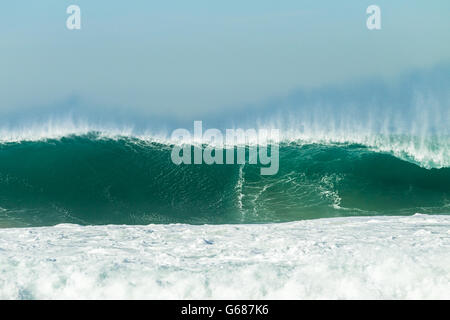 Gros plan des vagues d'océan s'écraser le long de l'eau bleu mur de plages. Banque D'Images