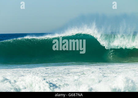Gros plan des vagues d'océan s'écraser le long de l'eau bleu mur de plages. Banque D'Images