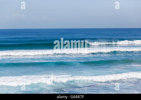 S'écraser des vagues d'océan d'eau bleue mur le long de plages. Banque D'Images