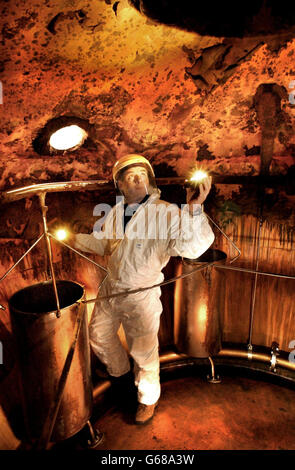 Walter Baker, agent de production, enquête à l'intérieur d'un whisky en pot de cuivre, l'un des deux produisant chaque année 1.3 millions de litres de whisky pur malt à la distillerie Glenkinchie à East Lothian. Les pots ont été vidés pour être nettoyés avant qu'un nouveau lot ne soit effectué. Banque D'Images