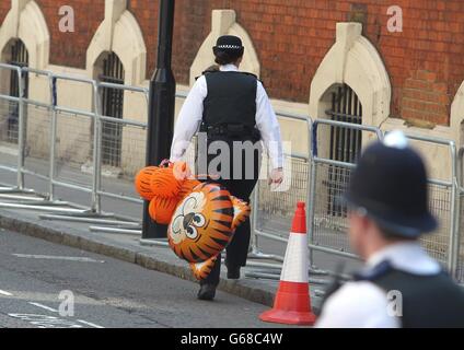 Un policier transporte des ballons donnés par un membre du public à l'extérieur de l'aile Lindo de l'hôpital St Mary's de Londres comme la duchesse de Cambridge a été admise à l'hôpital dans les premiers stades du travail, a déclaré Kensington Palace aujourd'hui. Banque D'Images