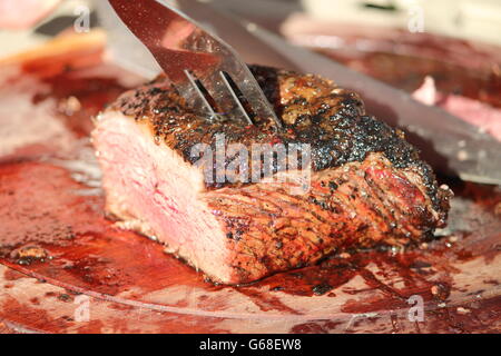 Une coupe parfaitement grillé, premier rose Pavé de boeuf avec un couteau et une fourchette d'argent Banque D'Images