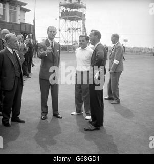 Le prince Philip, le duc d'Édimbourg, lance une pièce pour lancer le match de golf Britain v. Overseas, qui se joue aujourd'hui sur le parcours du North Shore Golf Club, Blackpool, à l'aide de son programme de prix. Le regarder est (à gauche) Dai Rees en Grande-Bretagne et (à droite) Arnold Palmer en Amérique. Banque D'Images