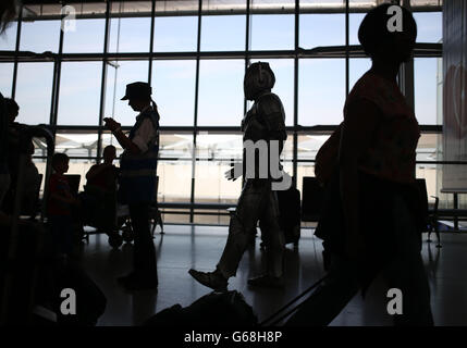 Un Cyberman traversant le terminal 5 de l'aéroport d'Heathrow à Londres dans le cadre d'une promotion estivale avec Doctor Who et BBC Worldwide. Banque D'Images